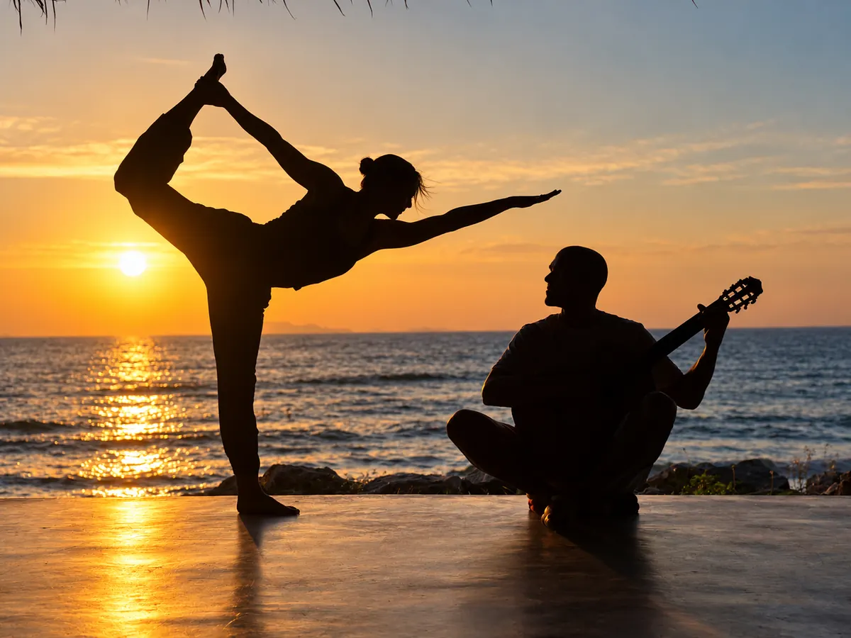 Yoga bei Sonnenuntergang am Meer, begleitet von einem Gitarristen